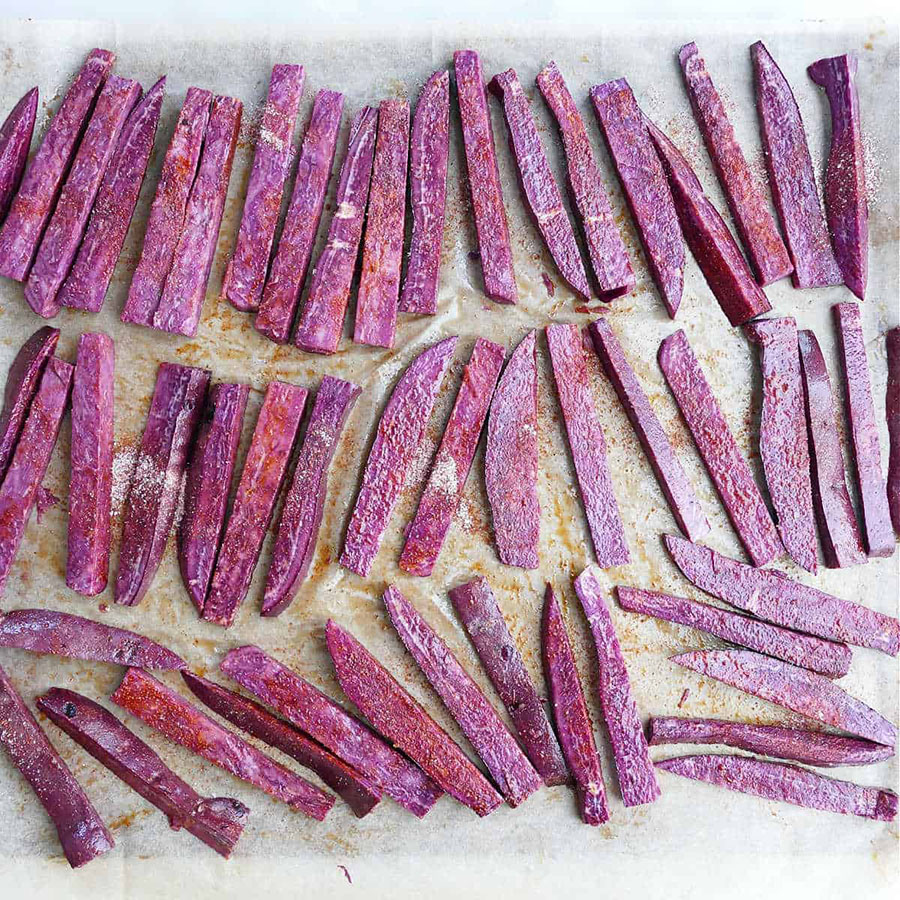 Step 4: Adding seasoning, mixing, and putting fries onto baking sheet